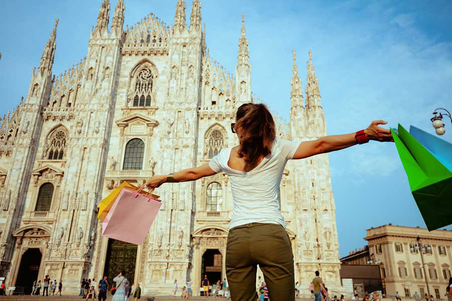 Donna felice con borse della spesa davanti al Duomo di Milano