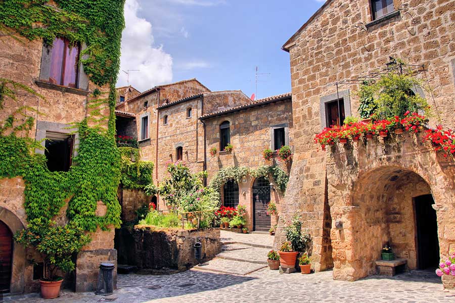 Stradina pittoresca in un borgo italiano con edifici in pietra e fiori